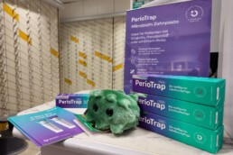 PerioTrap Mikrobiom-Zahnpasta beim Softlaunch in Halle – Produktaufsteller in Apotheke mit Broschüre und grünem Plüschbakterium